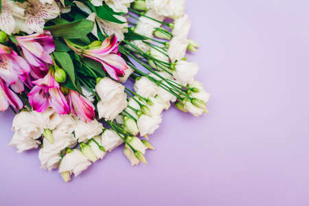 Spring flowers. International Women's day purple background. Bouquet of white, pink eustoma and...