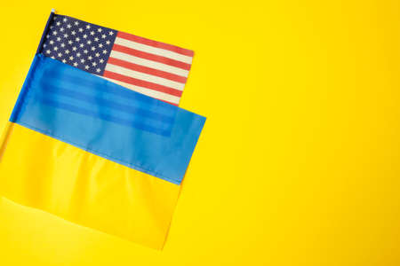 Ukrainian and american flags during war with Russia. Invasion in Ukraine. Sanctions against aggressor. Space mockupの写真素材