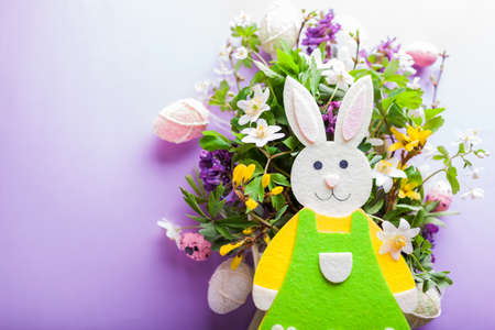 Happy Easter. Easter background with bunny spring yellow white flowers and eggs on purple background. Holiday symbol. Space. Close upの写真素材