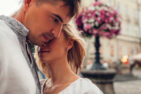 Close up portrait of loving couple walking in old Lviv city wearing traditional national ukrainian shirts. Man and woman hug outdoors. Spaceの写真素材