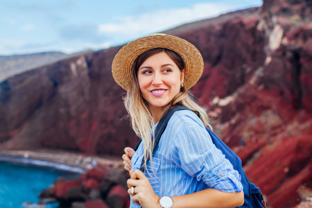 Tourist looking at Red beach landscape from view point in Akrotiri, Santorini island, Greece. Woman traveling the worldの写真素材