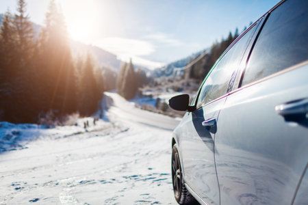 Traveling in winter by car during vacation. Holiday trip to snowy mountains. Blue auto stopped by frozen forest in Carpathians.の写真素材