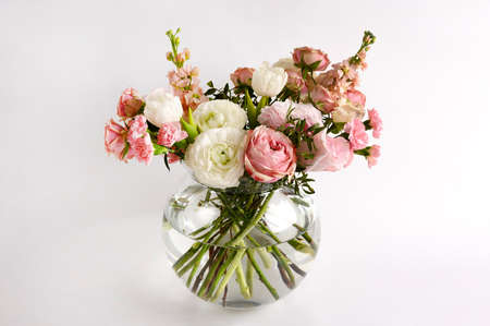 Beautiful flowers in vase on a table with white background. Womens, mothers day, love concept. Spring, summer season. Front view.の写真素材
