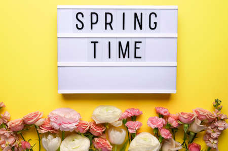 Composition with lightbox and flowers on yellow background. Womens day, month. Spring time. Flat lay.の写真素材