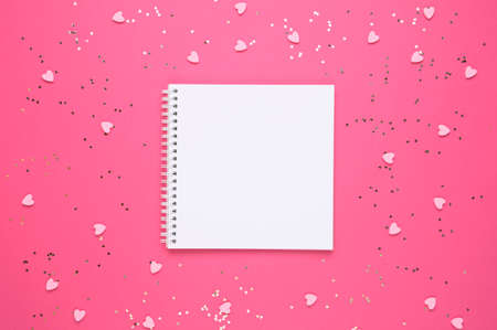 White empty sheet in notebook on a pink background with hearts. Copy space. Place to your text. Valentines, womens day, love concept. Top view.の写真素材