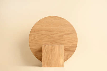Round wooden podium on beige background for product presentation. Front view. Copy space.の写真素材