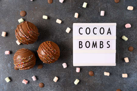 Cocoa bombs with marshmallows, chocolate that melts when hot milk is added for creating a trendy tasty drink. Food flatlay with lightbox. Top viewの写真素材