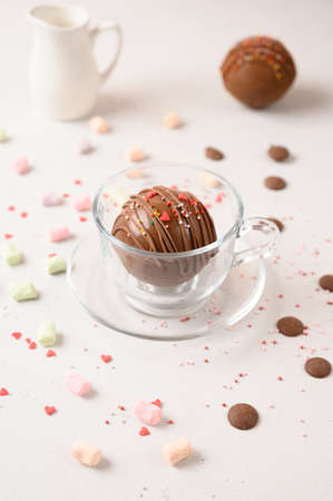 Cocoa bomb in the cup with marshmallows, chocolate that melts when hot milk is added for creating a trendy tasty drink. Front view.の写真素材