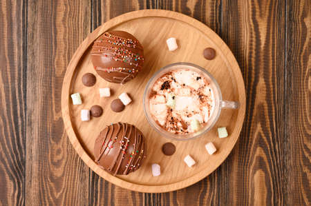 Cocoa bombs with marshmallows, chocolate that melts when hot milk is added for creating a trendy tasty drink. Wooden background. Top view.の写真素材