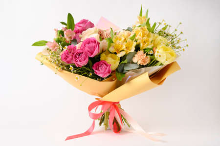 Beautiful flowers in vase on a table with white background. Womens, mothers day, love concept. Spring, summer season. Front view.の写真素材