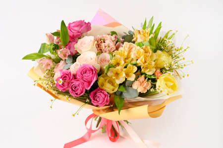 Beautiful flowers in vase on a table with white background. Womens, mothers day, love concept. Spring, summer season. Front view.の写真素材