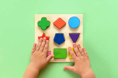 The child collects a multicolored wooden sorter. Educational logic toy for kidsの写真素材