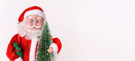 Santa Claus with miniature fir tree and gift bag on christmas time on white background. Front view. Banner. Copy space.の写真素材