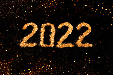 Festive numbers 2022 made of golden glitter on black background with lights. Christmas, winter, new year concept. Flat lay, top view, copy space.の写真素材