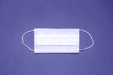 Disposable medical face mask. Christmas, 2021 new year concept. Stay safe. Top view, flat lay. Trendy color of the year 2022. Very periの写真素材