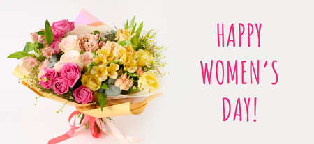 Bouquet with beautiful flowers on a table with white background. Womens day. Spring season. Front view. Banner with textの写真素材