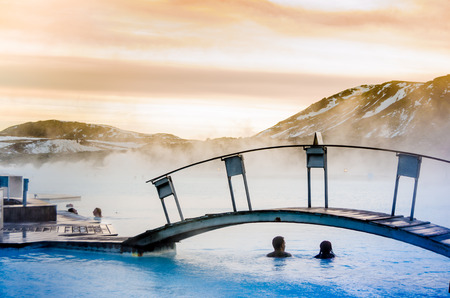 a couple under the bridge in the thermal blue lagoon, Iceland