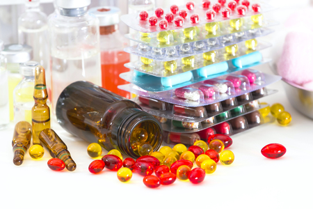 Multi-colored pills and capsules, medicine bottles, blood tubes.の写真素材
