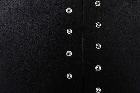 Black texture with two parallel lines of metal buttons.の写真素材