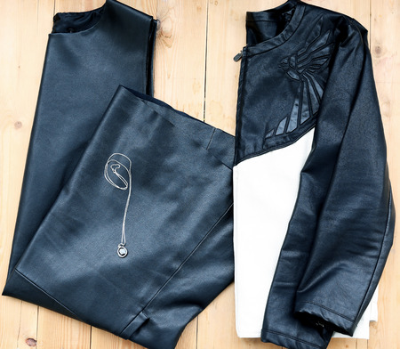 Total woman evening outfit, top view of black leather dress and jacket with evening accessoryの写真素材