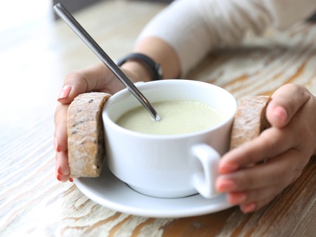Bowl with cream brocolli soup and breadの写真素材