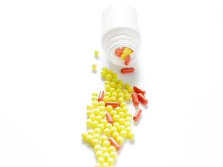 White medical jar with colorful vitaminsの写真素材