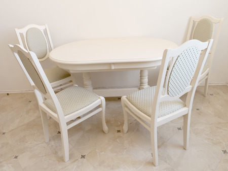 Beige classical dining room with roung table and chairs closed to the wallの写真素材
