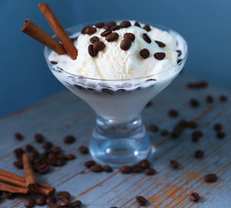 White ice-cream is with sinabon and coffee on the blue table in rustic style.の写真素材