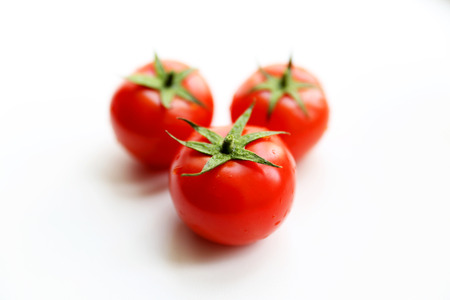 Bunch of red tasty fresh tomatos on the white background.の写真素材