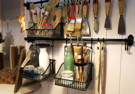 Some brushes with other needed stuff for repairing and making arts. They are located on the wall which is woodenの写真素材