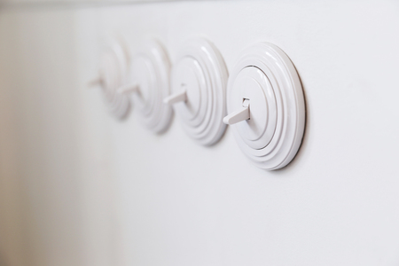 Light white round switch in off position. It is located in the kitchen on white wall in a row.の写真素材