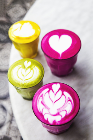 Beetroot, matcha,turmeric lattes are on the marble table with art floor on the background, Trendy healthy antioxydant drinksの写真素材