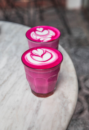 Two colorful trendy pink beetroot latte on white marbel background.の写真素材