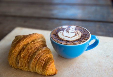 Cup of hot cappucino is on wooden table background. hippster styleの写真素材