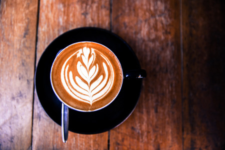 Cup of hot cappucino is on wooden table background. hippster styleの写真素材