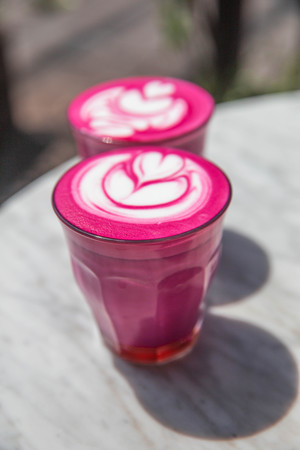 Two colorful trendy pink beetroot latte on white marbel background.の写真素材