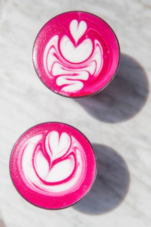 Two colorful trendy pink beetroot latte on white marbel background.の写真素材