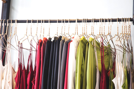 Fashionable clothes is hanging in the storeの写真素材