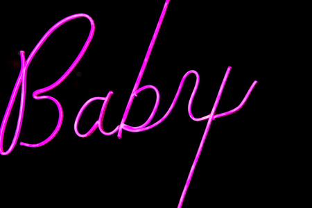 Baby word in proton purple neon color on black background.の写真素材