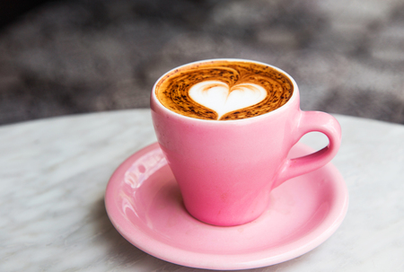 Cappuccino cup with heart latte art on marble table background.の写真素材