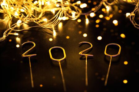 Luxury sparkling numbers 2020 with golden lights on black background. Holiday festive concept.の写真素材