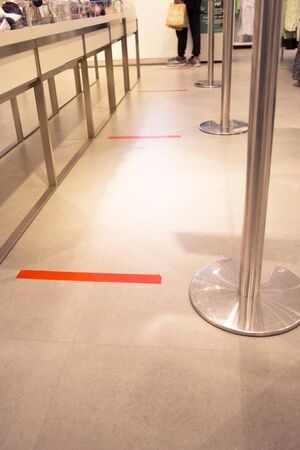 The red tape stick on the floor as a practicing of the Social Distanceの写真素材