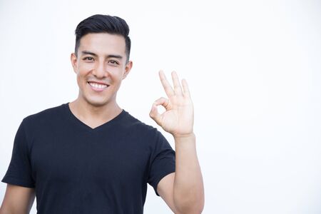 Happy excited young man making okay sign with fingers.の写真素材