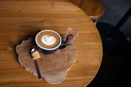 Cup of tasty cappucino with love art latte. Valentine's day concept. wooden tabele backdrop.の写真素材