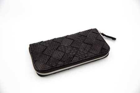 Deep black snakeskin wallet purse isolated on a white background. Fashion concept.の写真素材