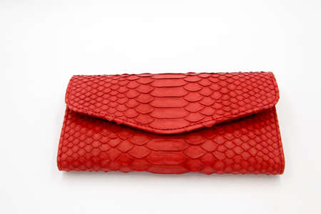 Trendy natural red snake python skin woman wallet on white isolated background. Can be used for background and wallpaperの写真素材