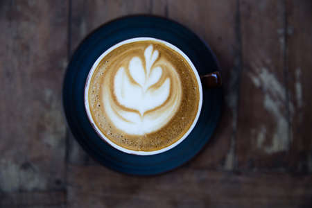 Cup of hot cappucino on wooden table background