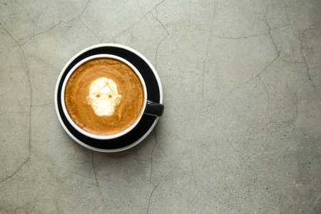 Cappuccino with latte art man in facial mask on gray concrete background. Heathy protection concept. Place for text.の写真素材