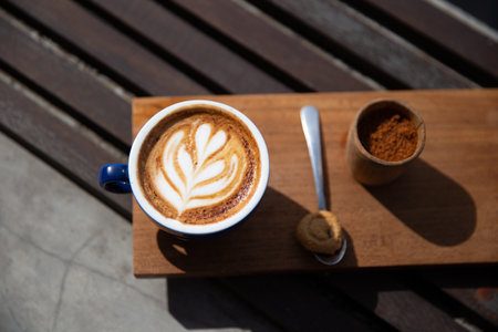 cup of cappuccino with latte art with spoon on the wooden backgroundの写真素材