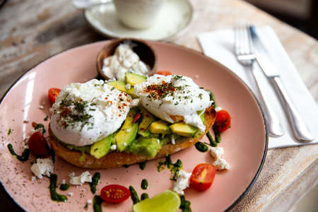 Whole wheat toasted bread with avocado and poached eggsの写真素材